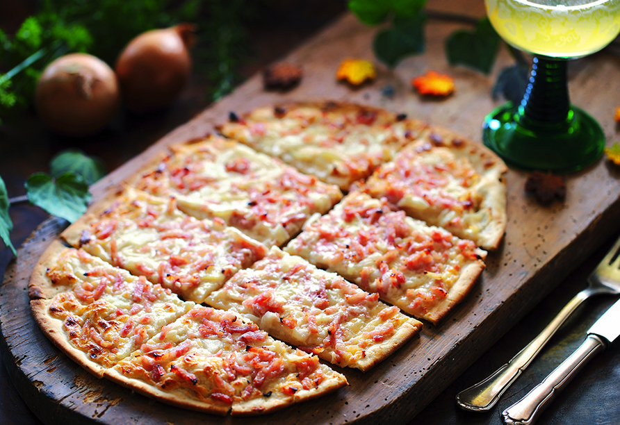 Genießen Sie die elsässische Küche, wie einen klassischen Flammkuchen.