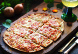 Genießen Sie die elsässische Küche, wie einen klassischen Flammkuchen.