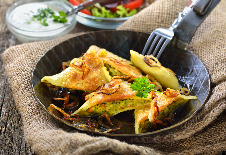 Gebratene, schwäbische Maultaschen mit Röstzwiebeln, Kräuterquark und Salat rustikal serviert