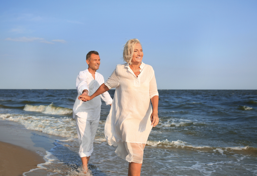 Spazieren Sie am traumhaften Strand entlang des Wassers.