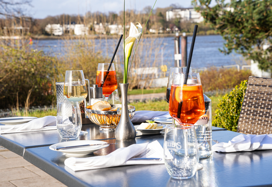 Beobachten Sie von  der Terrasse Ihres Hotels bei kulinarischen Köstlichkeiten und kühlen Drinks das rege Treiben auf der Elbe.