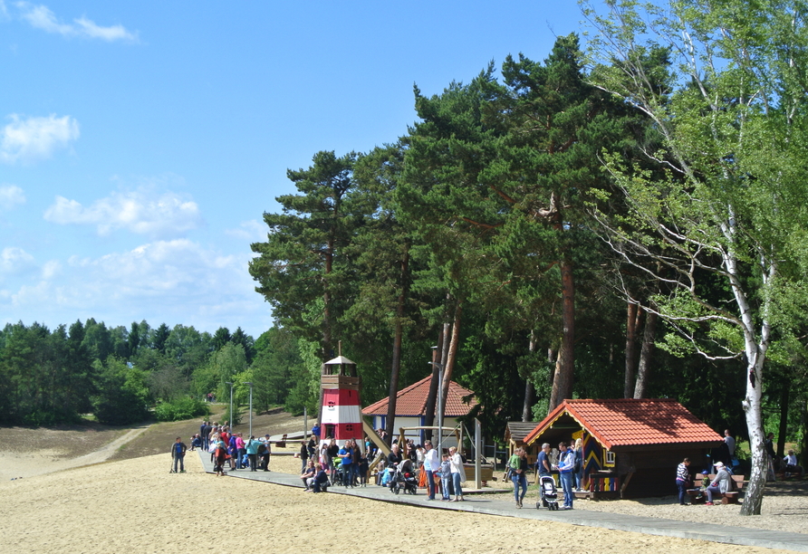 Kinder toben sich direkt am Strand auf dem großen Abenteuerspielplatz aus.