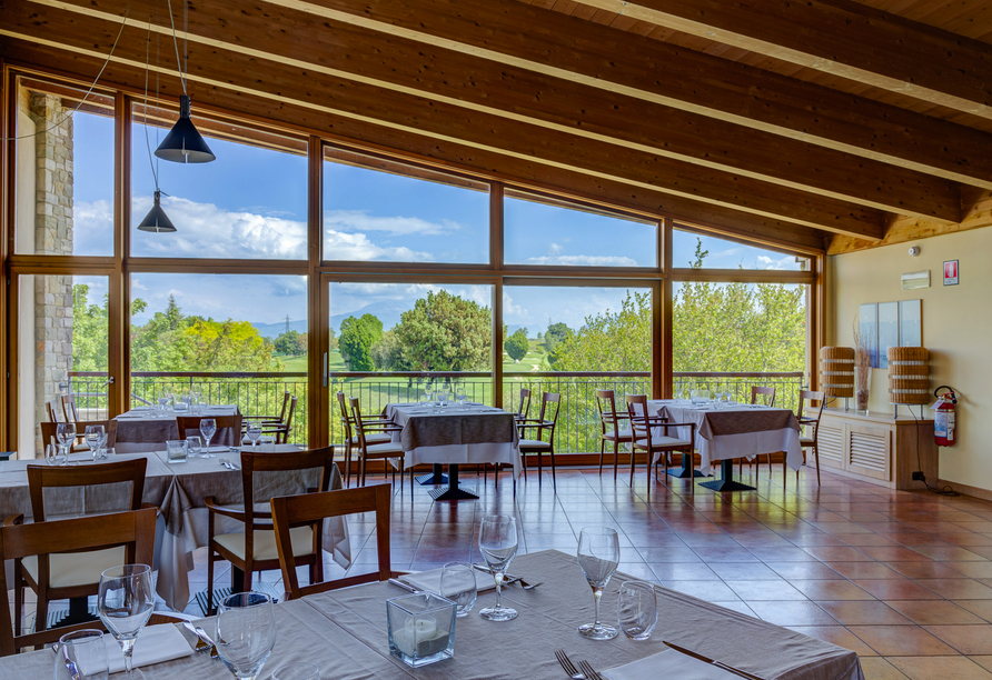 Genießen Sie beim Essen im Restaurant Ihres Hotels den Ausblick auf die weitläufigen Grünanlagen.