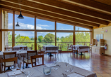 Genießen Sie beim Essen im Restaurant Ihres Hotels den Ausblick auf die weitläufigen Grünanlagen.