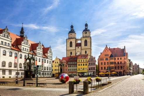 Willkommen in Wittenberg! Schlendern Sie durch die charmanten Straßen und entdecken Sie den Marktplatz mit der Kirche.