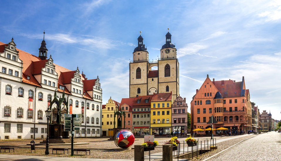 Willkommen in Wittenberg! Schlendern Sie durch die charmanten Straßen und entdecken Sie den Marktplatz mit der Kirche.