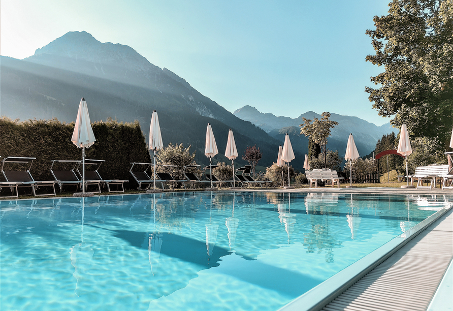 Erholen Sie sich von einem ereignisreichen Tag am Außenpool des Hotels und lassen Sie den Blick über das Bergpanorama schweifen.