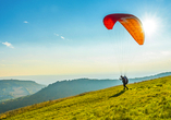 Machen Sie einen Gleitschirmflug und schauen Sie sich die Davoser Berge von oben an.