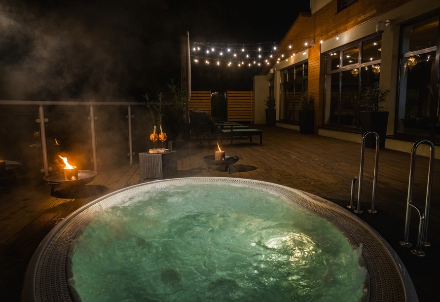 Entspannen Sie im Whirlpool auf der gemütlichen Dachterrasse.