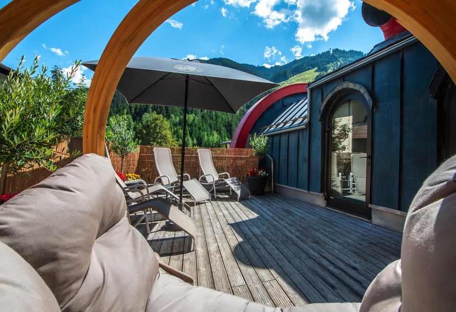 Auf der Terrasse des Wellnessbereichs können Sie wunderbar entspannen und den Blick auf die Berge genießen.