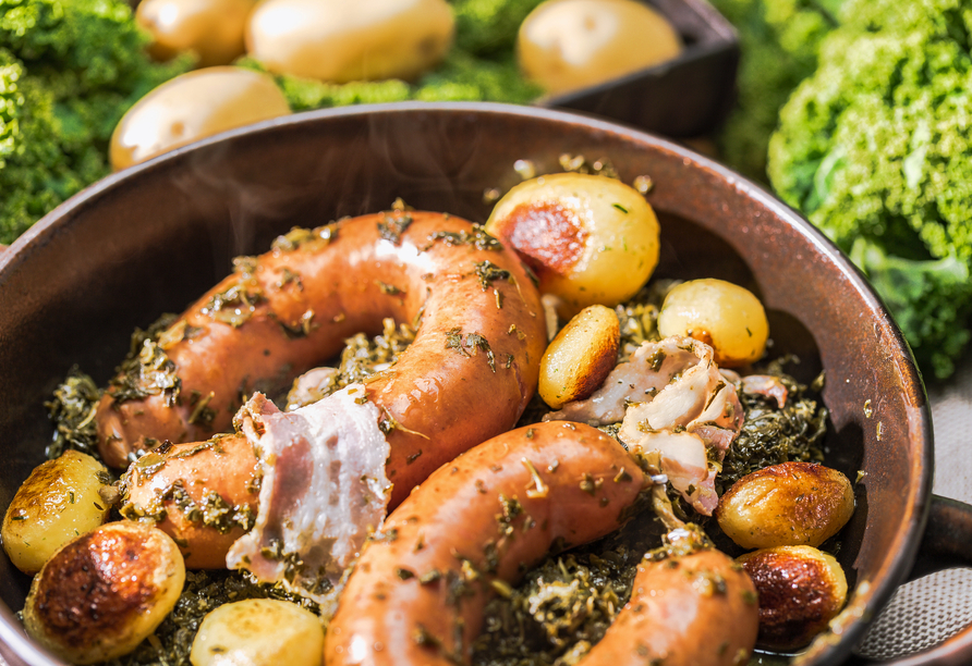 Probieren Sie das lokale Gericht Grünkohl mit Bregenwurst.