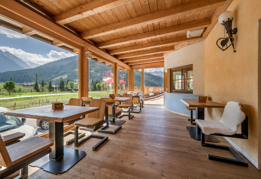 Die weitläufigen Panoramafenster bieten einen freien Blick auf die beeindruckende Alpenlandschaft.