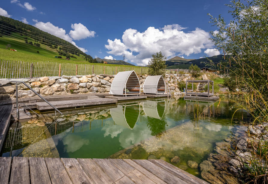 Genießen Sie eine erfrischende Auszeit im Naturbadeteich des Hotels und lassen Sie sich von der traumhaften Panoramasicht verzaubern.